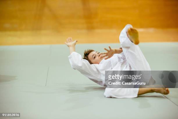 young judo student limbering up before judo training - martial arts stock pictures, royalty-free photos & images