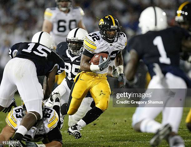 Adam Robinson of the Iowa Hawkeye's tries to find running room between Ollie Ogbu, Bani Gbadyu and A.J. Wallace of the Penn State Nittnay Lions on...