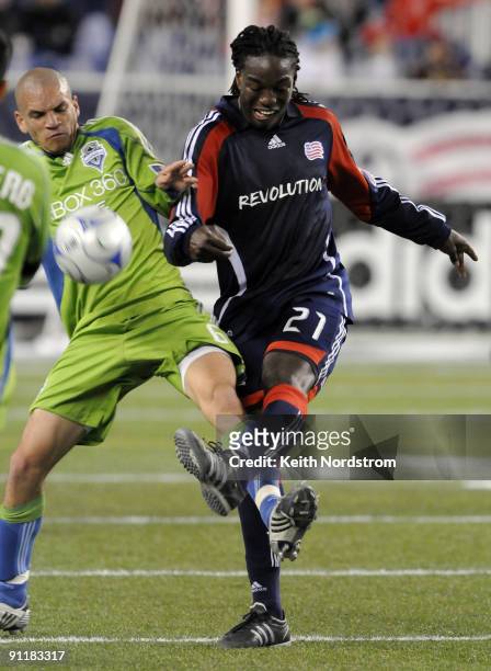 Shalrie Joseph of the New England Revolution kicks the ball away fromf Osvaldo Alonso of the Seattle Sounders FC during a MLS match on September 26,...