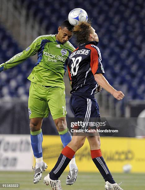 Edgaras Jankauskas of the New England Revolution fights for a 50-50 ball with Tyrone Marshall of the Seattle Sounders FC during a MLS match on...