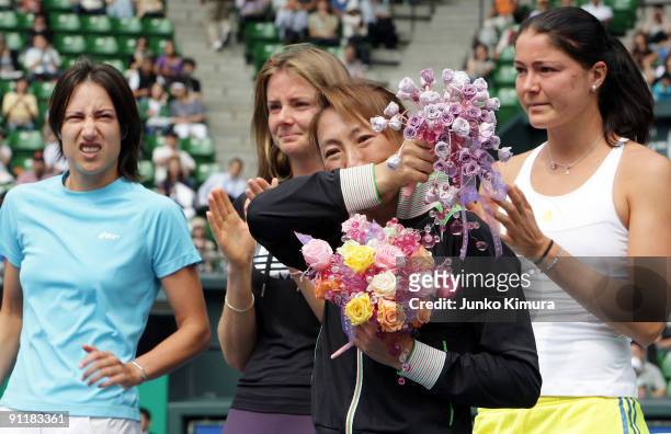 Ai Sugiyama of Japan is applauded by fellow players during a special ceremony on day one of the Toray Pan Pacific Open Tennis tournament at Ariake...