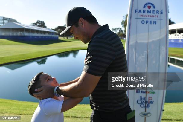 Jason Day of Australia celebrates with his son, Dash, after winning the Farmers Insurance Open on the sixth playoff at Torrey Pines South on January...