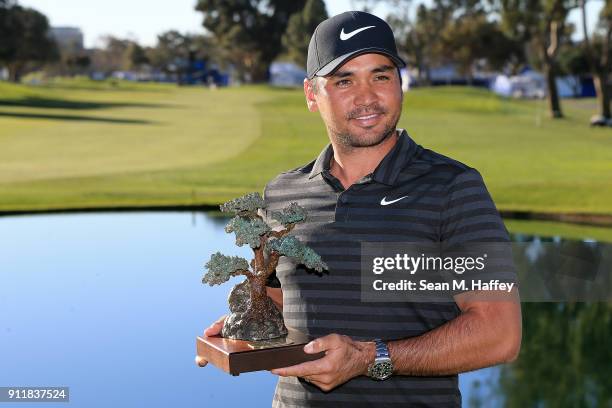 Jason Day of Australia poses with the trophy after the sixth playoff on the 18th hole to win the Farmers Insurance Open at Torrey Pines South on...