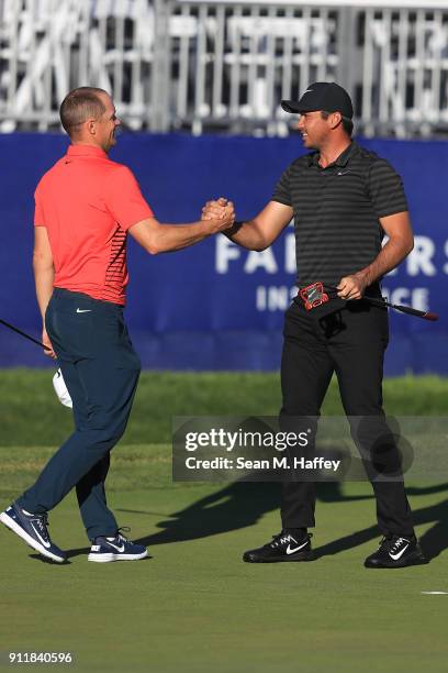 Jason Day of Australia shakes hands with Alex Noren of Sweden on the sixth playoff on the 18th green after winning the Farmers Insurance Open at...