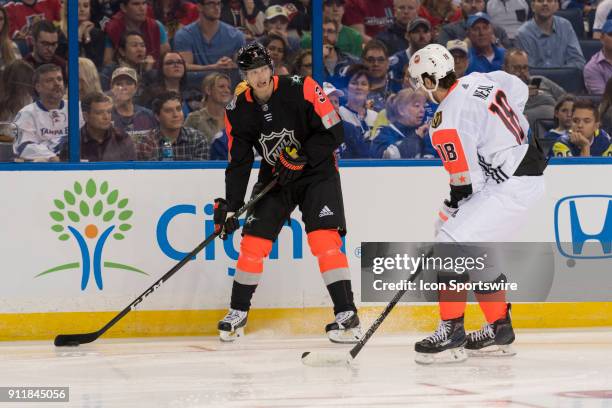 Central Division defender John Klingberg is defended by Pacific Division forward James Neal during the first game of the NHL All-Star Game between...