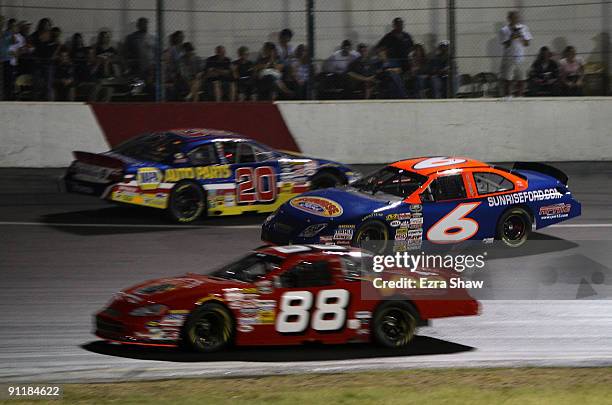 Jason Bowles driver of the SunriseFord.com Ford passes Eric Holmes driver of the NAPA Toyota during an early accident in the Toyota Copart 150 NASCAR...