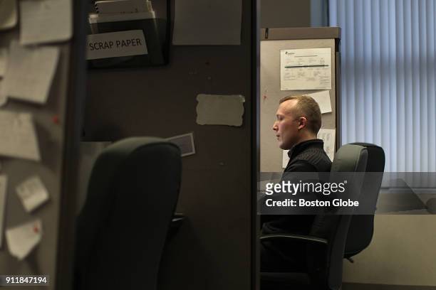 Jarrod LaBarge, a volunteer at the Samaritans suicide hotline, works in his cubicle during a shift in Boston on Dec. 15, 2017. LaBarge assists...