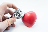 Doctor holding stethoscope in his hand, examines heart shape for presence of diseases of cardiovascular system. Photo for use in cardiology, cardiac surgery, diagnosis and treatment of heart disease