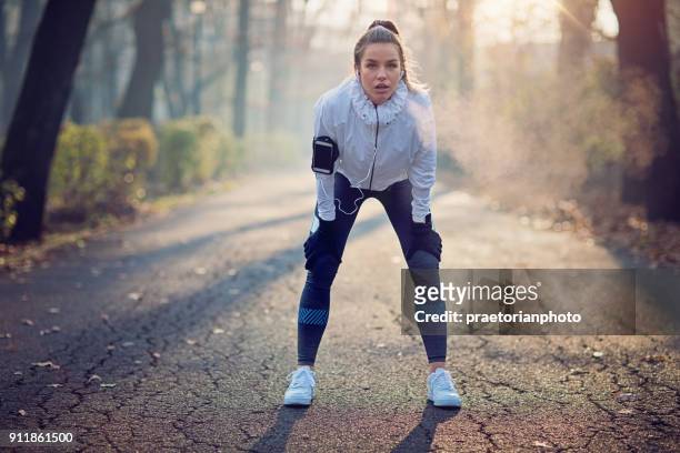 runner meisje is uitgeput in de mistige ochtend rusten - zichtbare adem stockfoto's en -beelden