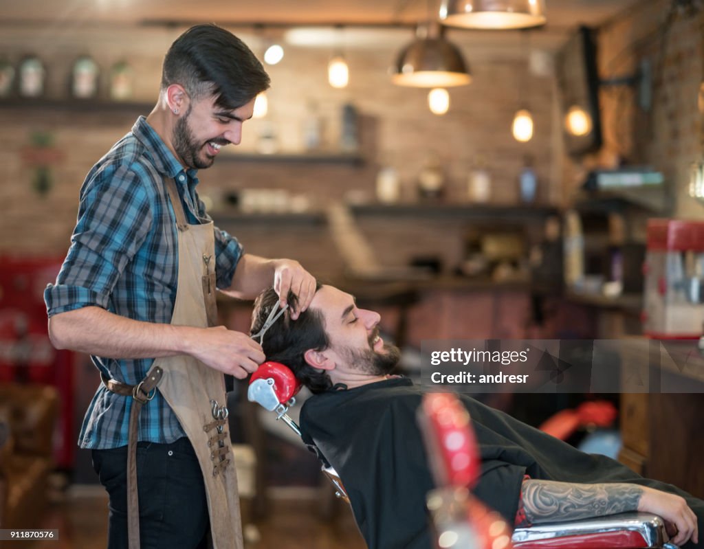 Uomo felice che si taglia i capelli al barbiere
