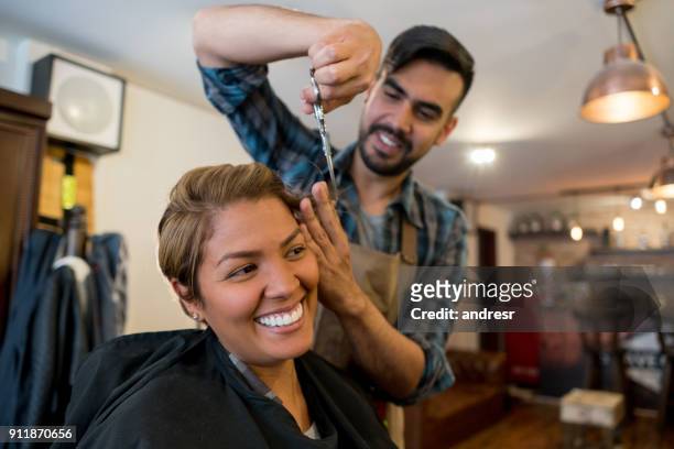 happy woman getting a haircut at the hairdresser - short hair cut stock pictures, royalty-free photos & images