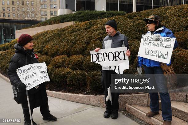 Pro Donald Trump protesters holds up signs calling for deportation as dozens of immigration activists, clergy members and others participate in a...