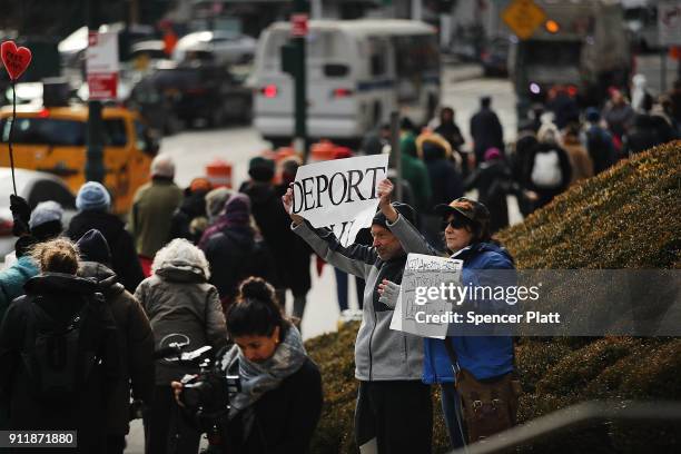 Pro Donald Trump protester holds up a sign calling for deportation as dozens of immigration activists, clergy members and others participate in a...