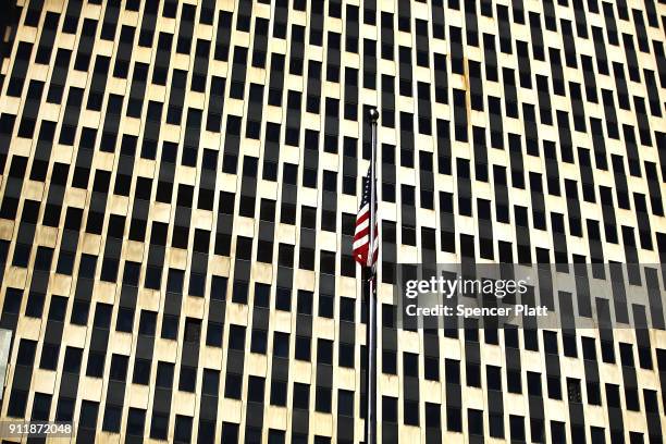 An American Flag hangs in front of the federal building as dozens of immigration activists, clergy members and others participate in a demonstration...