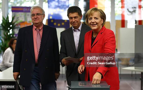 Chancellor Angela Merkel of the Christian Democratic Union party and her husband Joachim Sauer cast their ballots for German federal elections on...