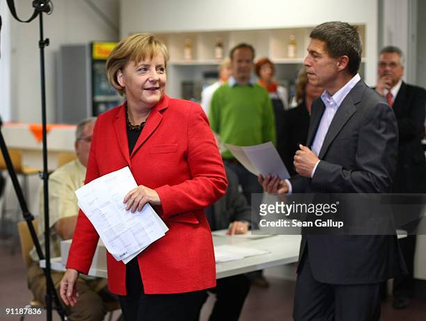 Chancellor Angela Merkel of the Christian Democratic Union party and her husband Joachim Sauer arrive for casting their ballots for German federal...