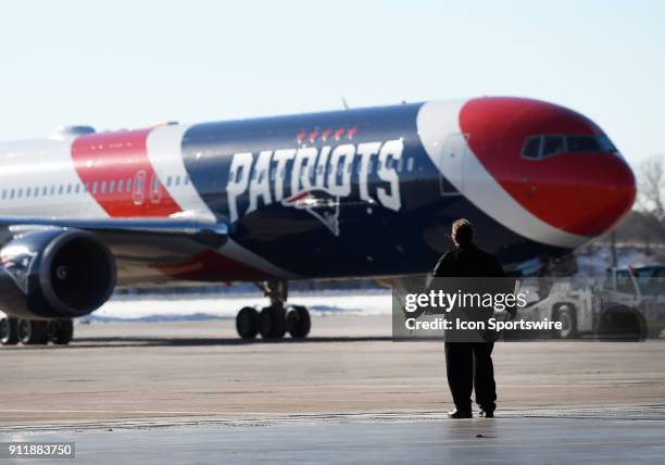 Member of the ground crew guides the team plane of the New England Patriots as it arrives for Super Bowl LII on January 29, 2018 at the...
