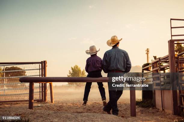 vader en zoon op rodeo arena - farm family stockfoto's en -beelden