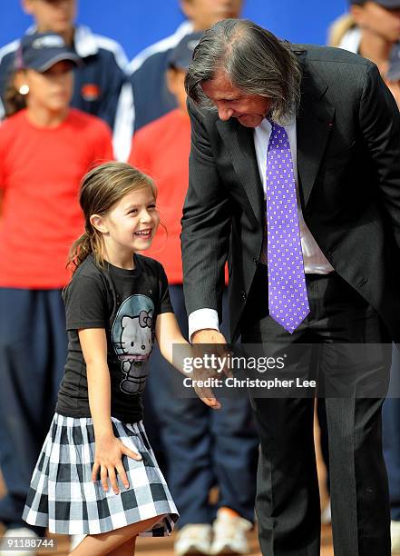 Ilie Nastase of Romania stands on court with a young member of his family during the trophy ceremony after the Final match of the BCR Open Romania at...