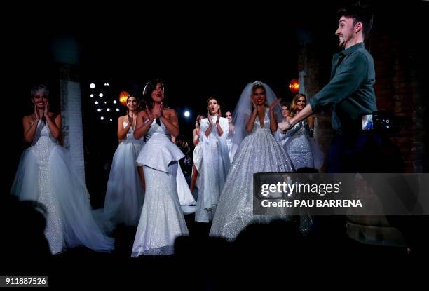 Models applaud as Spanish designer Jose Maria Garcia appears on the catwalk following the presentation of Ze Garcia collection during the 080...