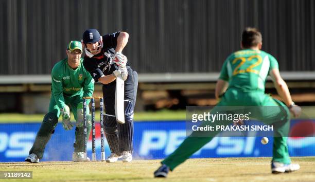 England's batsman Paul Collingwood plays a shot off South Africa's Johan Botha as Mark Boucher looks on during The ICC Champions Trophy match between...