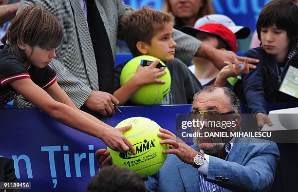 Former Romanian tennis player Ion Tiriac signs autographs for his fans during the ATP Romania Open final match tennis opposing Spain's Albert...