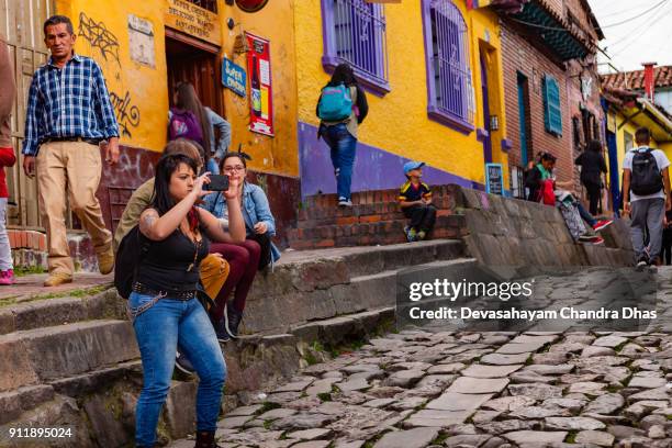 bogotá, colombia - los turistas y locales colombianos en las estrechas y empedradas, calle del embudo en el histórico barrio de candelaria de la capital de los andes - calle del embudo fotografías e imágenes de stock