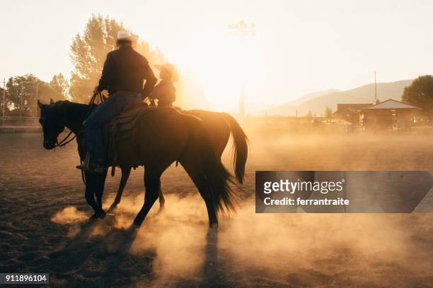 vater und sohn in rodeo arena - rodeo stock-fotos und bilder