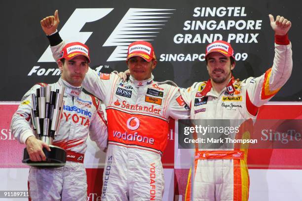 Race winner Lewis Hamilton of Great Britain and McLaren Mercedes celebrates on the podium with second placed Timo Glock of Germany and Toyota and...