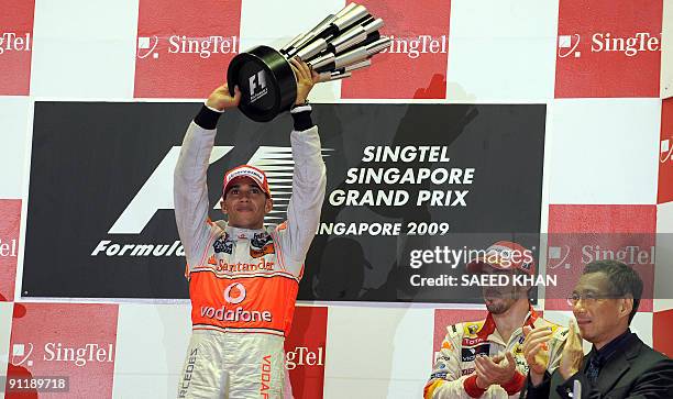 McLaren Mercedes driver Lewis Hamilton of Britain holds up the winner's trophy as he celebrates winning Formula One's 2009 Singapore Grand Prix in...