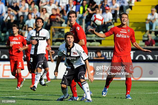 Alberto Paloschi of Parma FC competes for the ball with Michele Canini and Davide Astori of Cagliari Calcio during the Serie A match between Parma FC...