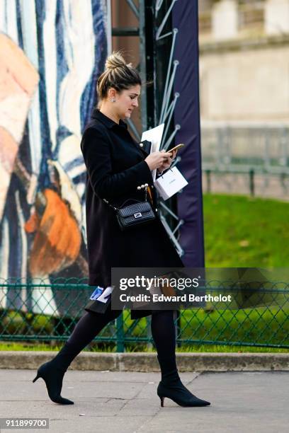 Guest wears a black coat and chanel bag, outside Chanel, during Paris Fashion Week -Haute Couture Spring/Summer 2018, on January 23, 2018 in Paris,...