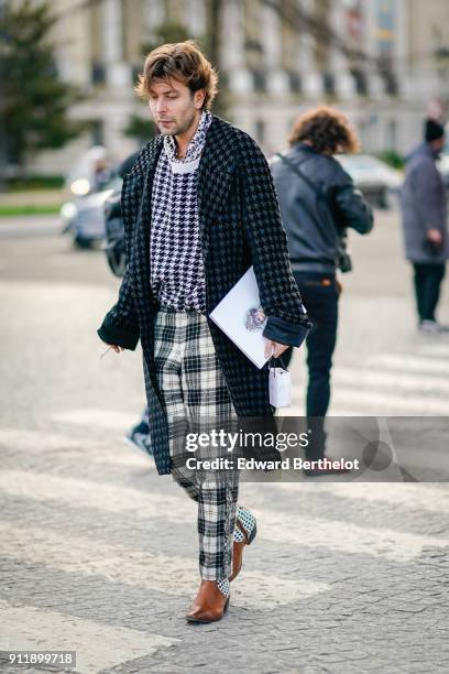 Guest wears a checked pattern coat, checked pants, brown shoes, outside Chanel, during Paris Fashion Week -Haute Couture Spring/Summer 2018, on...