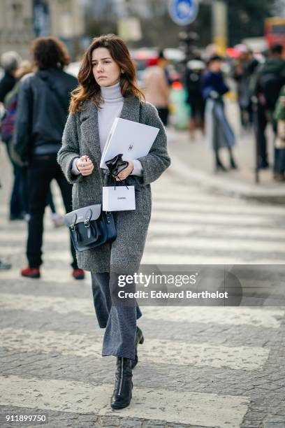Guest wears a gray coat, a gray turtleneck, cropped flare pants, black shoes, outside Chanel, during Paris Fashion Week -Haute Couture Spring/Summer...