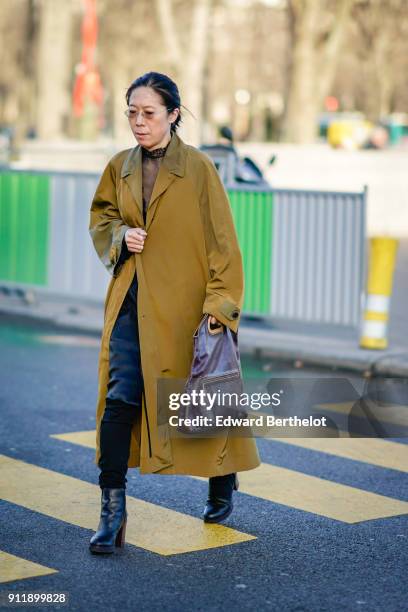 Guest wears a yellow coat, outside Chanel, during Paris Fashion Week -Haute Couture Spring/Summer 2018, on January 23, 2018 in Paris, France.