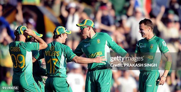 South African bowler Johan Botha celebrates the wicket of England's batsman Owais Shah with teammates during The ICC Champions Trophy match between...