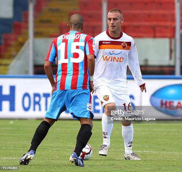 Daniele De Rossi of AS Roma is challenged by Takayuki Morimoto during the Serie A match between Catania Calcio and AS Roma at Stadio Angelo Massimino...