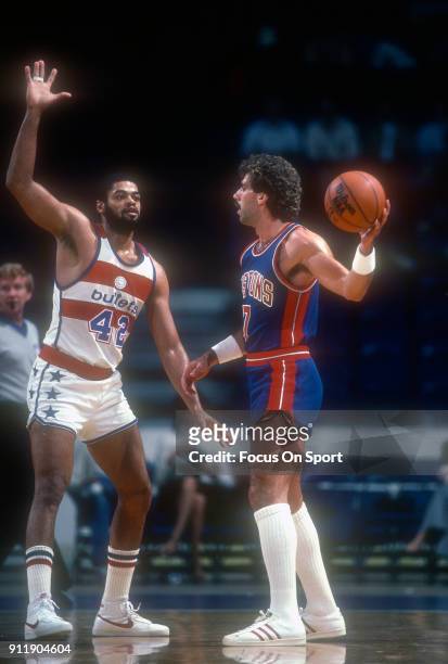 Kelly Tripucka of the Detroit Pistons looks to pass the ball past Greg Ballard of the Washington Bullets during an NBA basketball game circa 1982 at...