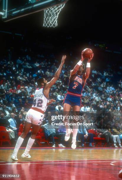 Kelly Tripucka of the Detroit Pistons goes up to shoot over Greg Ballard of the Washington Bullets during an NBA basketball game circa 1983 at the...