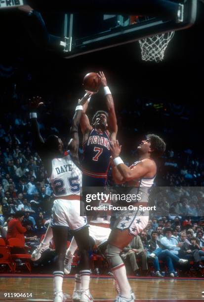 Kelly Tripucka of the Detroit Pistons goes to shoot over Darren Daye and Jeff Ruland of the Washington Bullets during an NBA basketball game circa...