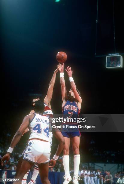 Kelly Tripucka of the Detroit Pistons shoots over Greg Ballard of the Washington Bullets during an NBA basketball game circa 1983 at the Capital...