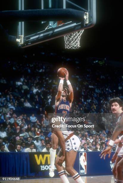 Kelly Tripucka of the Detroit Pistons shoots over Greg Ballard of the Washington Bullets during an NBA basketball game circa 1983 at the Capital...