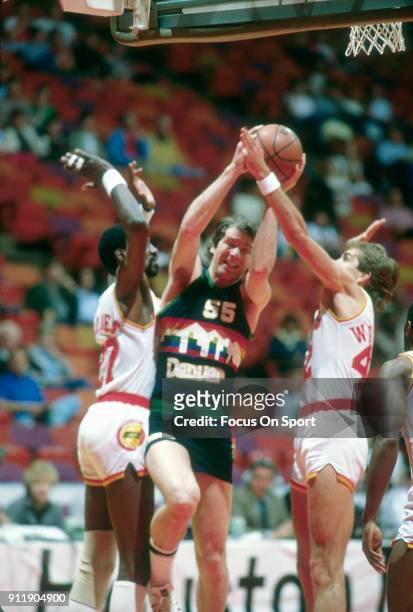 Kiki VanDeWeghe of the Denver Nuggets looks to get his shot off over Caldwell Jones and Wally Walker of the Houston Rockets during an NBA basketball...