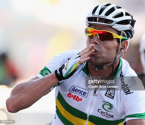 Cadel Evans of Australia waves as he crosses the finish line to win the Men's Road Race at the 2009 UCI Road World Championships on September 27,...