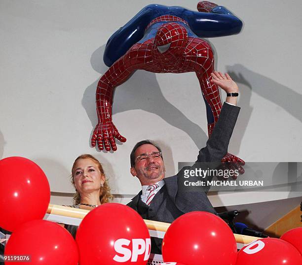 Brandenburg State Premier Matthias Platzeck and his wife Jeanette Jesorka stand under a spiderman figure after parliamentary elections and regional...