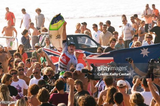 Mick Fanning of Australia is chaired up the beach on the shoulders of friends and peers after winning the final of the Quiksilver Pro on September...