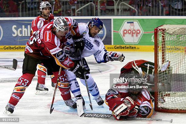 Yannic Seidenberg of Mannheim is challenged by Jason Holland and goalie Jean Sebastien Aubin of Duesseldorf during the DEL match between DEG Metro...