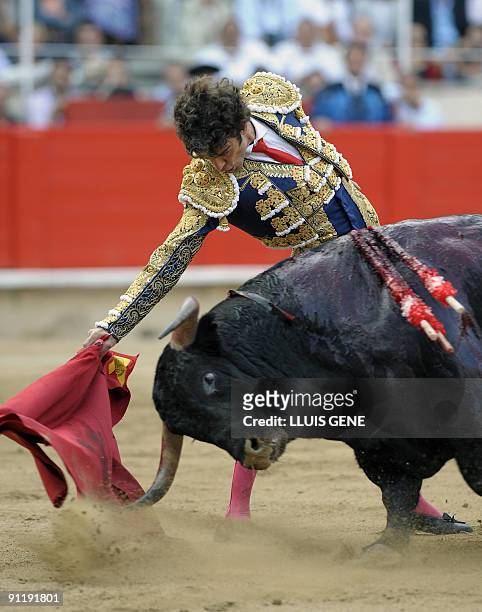 Spanish bullfighter Jose Tomas performs a pass on a bull at the Plaza Monumental bullring in Barcelona, on September 27, 2009. AFP PHOTO/LLUIS GENE.