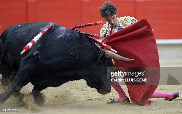 Spanish bullfighter Jose Tomas performs a pass on a bull at the Plaza Monumental bullring in Barcelona, on September 27, 2009. AFP PHOTO/LLUIS GENE