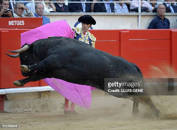 Spanish bullfighter Jose Tomas performs a pass on a bull at the Plaza Monumental bullring in Barcelona, on September 27, 2009. AFP PHOTO/LLUIS GENE.